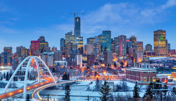 Edmonton Downtown Skyline Just After Sunset in the Winter Edmonton downtown Winter skyline just after sunset at the blue hour showing Walterdale Bridge across the frozen, snow-covered Saskatchewan River and surrounding skyscrapers. Edmonton is the capital of Alberta, Canada. alberta stock pictures, royalty-free photos & images