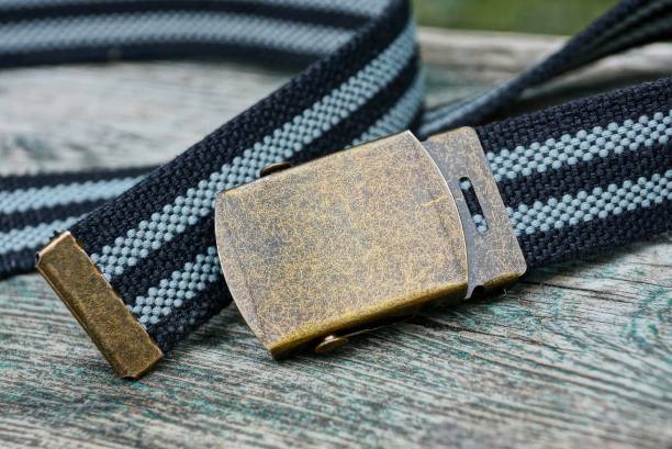 istock striped fabric belt with metallic brown buckle on gray table 1089143614