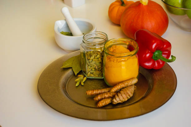 colorful indian spices turmeric and cardamom in a glass jar and mortar for spices close up. - cardamom cinnamon mortar and pestle herb imagens e fotografias de stock