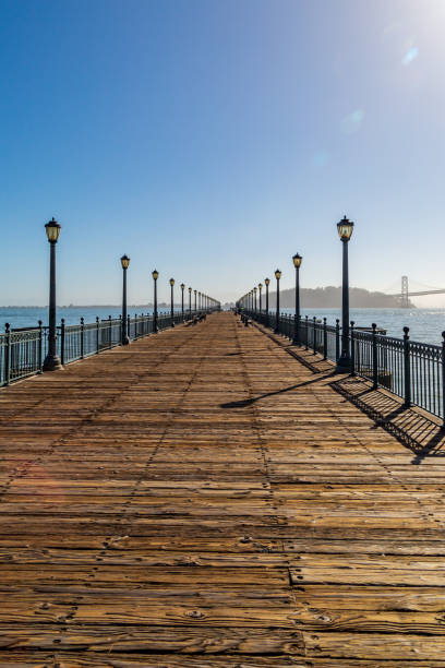 eine promenade an der küste in san francisco - san francisco county embarcadero center bay bridge built structure stock-fotos und bilder