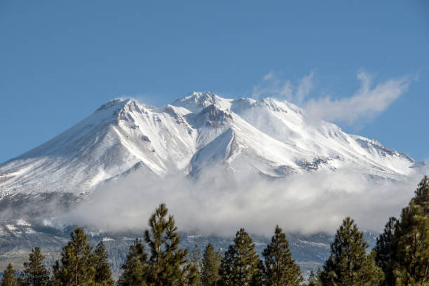 Mt Shasta with clouds Mt Shasta as seen from Mt Shasta (city), California, USA (from southwest). Blowing snow at the summit and moist air around the mountain allow Mt Shasta to create it"u2019s own clouds. mt shasta stock pictures, royalty-free photos & images