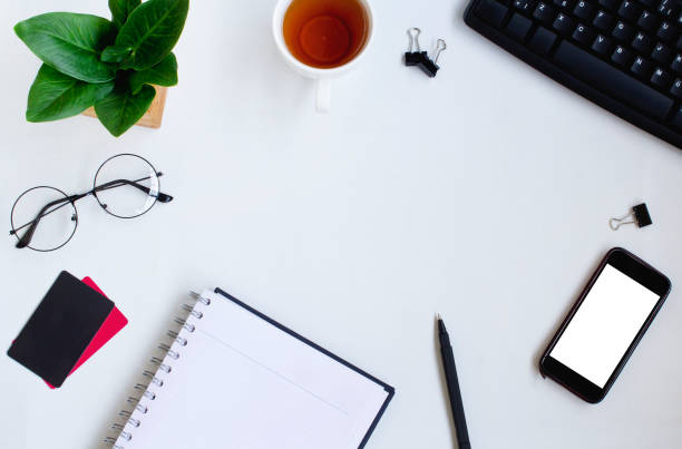 istock Smartphone, keyboard, notebook and credit carrds on white office desk. 1089160450