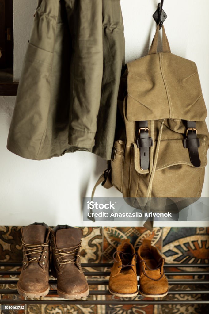 Autumn brown shoes and a backpack stand on a shelf in the hallway of the house Corridor Stock Photo