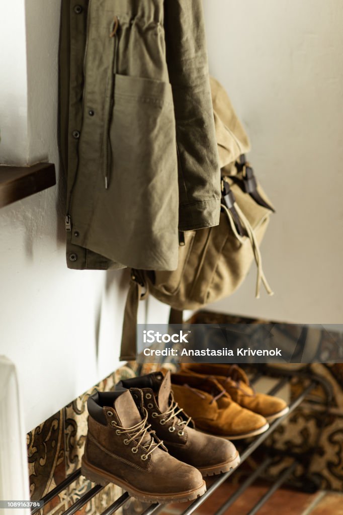 Autumn brown shoes and a backpack stand on a shelf in the hallway of the house Corridor Stock Photo