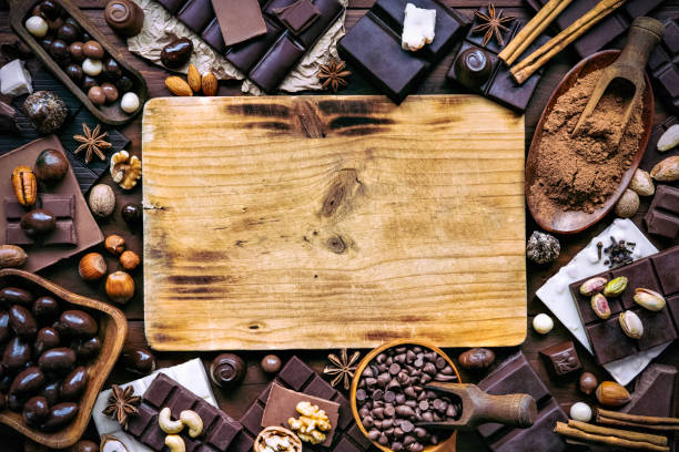 istock Assorted chocolate, nuts and dried fruit in old fashioned style with cutting board and drawing board and copy space 1089167094