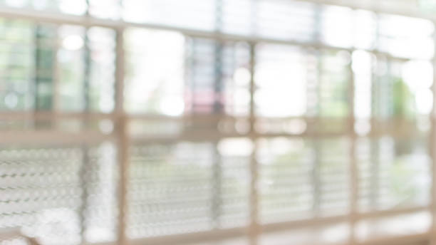 istock Corridor in school or office building blur background with blurry interior view empty hall way, glass curtain wall and floor with exterior light illumination 1089173196