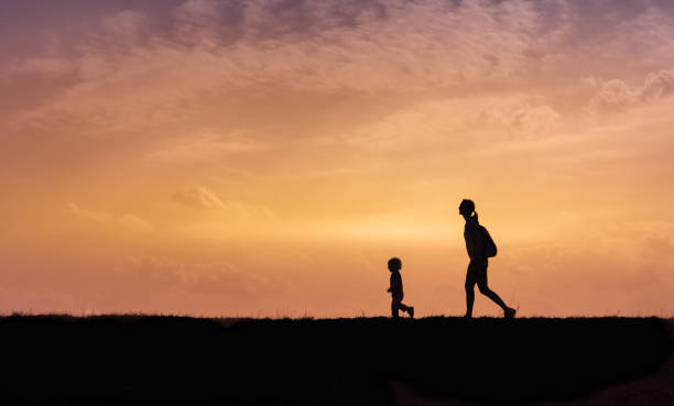 istock Mother and son walking together at sunset. 1089173920
