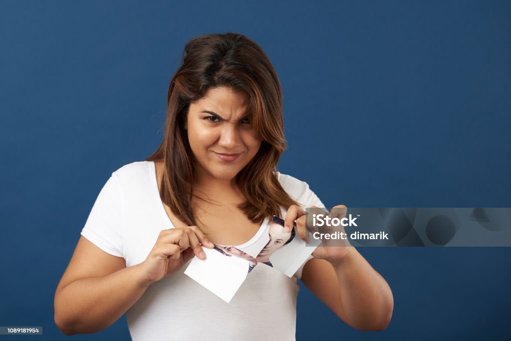 Angry girl on boyfriend Angry girl on boyfriend tearing his photo apart Former Stock Photo