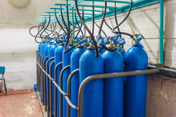 bundle of blue gas cylinders with pressure gauges - helium imagens e fotografias de stock