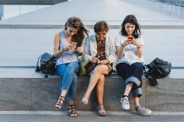 istock Mother and daughters using smartphones in the city 1089190110