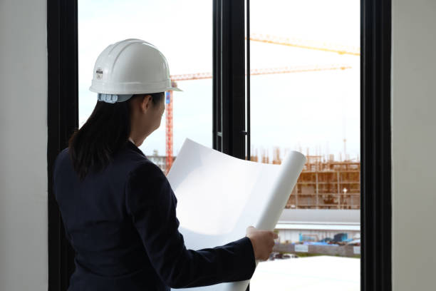istock Engineering Consulting People on construction site holding blueprint in his hand. Building inspector. Construction site check drawing and business workflow of new building 1089217848