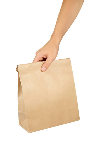 istock Right hand holding a brown paper bag isolated on white with clipping path. 1089217854