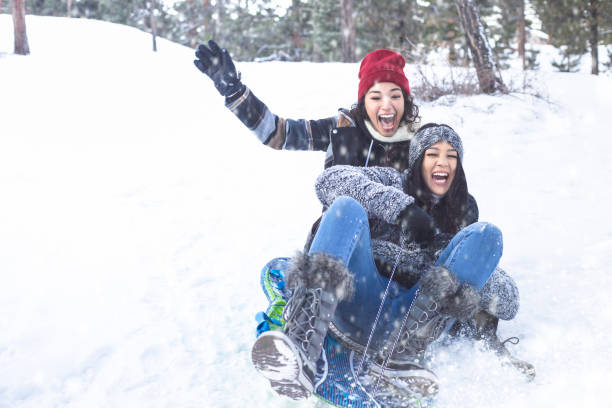 dos mejores amigos en las vacaciones de invierno. - deslizarse en trineo fotografías e imágenes de stock