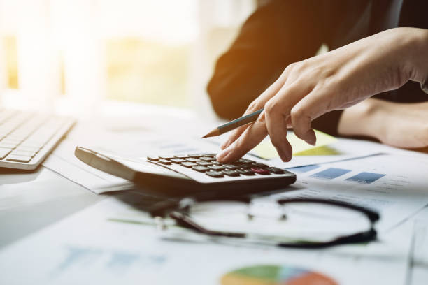 istock Accountant with calculator counting making notes at office hand is writes in a postit sticky 1089223186