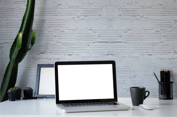 istock Workspace Mockup laptop, coffee and cactus on office table and office supplies with brick wall background. 1089229064