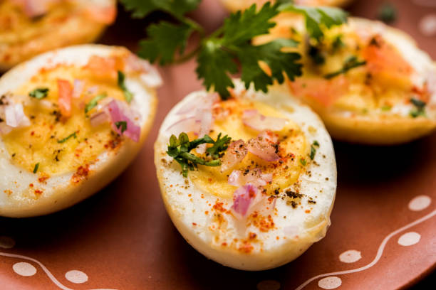 istock Fried hot boiled egg masala is a popular healthy breakfast or starter menu from India. With onion, coriander, black pepper, tomato and salt sprinkled over half of eggs 1089229862
