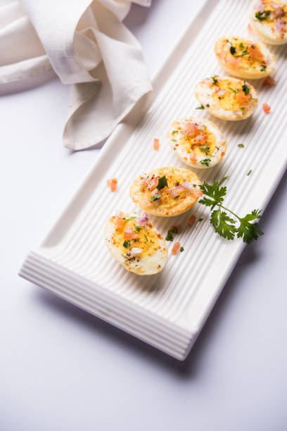 istock Fried hot boiled egg masala is a popular healthy breakfast or starter menu from India. With onion, coriander, black pepper, tomato and salt sprinkled over half of eggs 1089231188