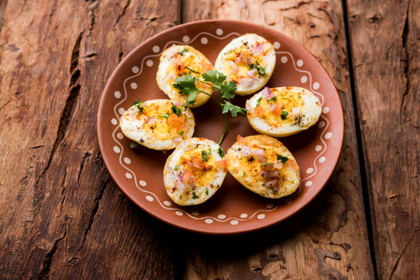 istock Fried hot boiled egg masala is a popular healthy breakfast or starter menu from India. With onion, coriander, black pepper, tomato and salt sprinkled over half of eggs 1089231736