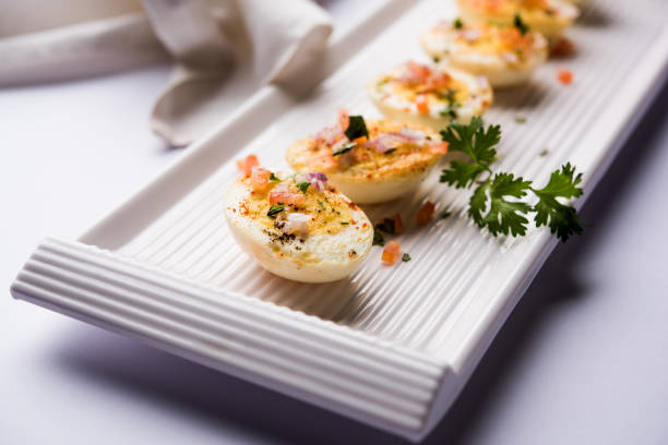 istock Fried hot boiled egg masala is a popular healthy breakfast or starter menu from India. With onion, coriander, black pepper, tomato and salt sprinkled over half of eggs 1089231832