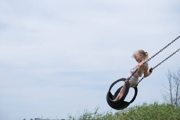 istock Little girl plays on the swing 1089231984