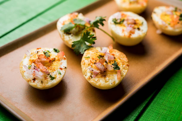 istock Fried hot boiled egg masala is a popular healthy breakfast or starter menu from India. With onion, coriander, black pepper, tomato and salt sprinkled over half of eggs 1089232164