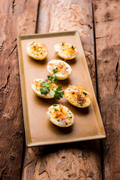 istock Fried hot boiled egg masala is a popular healthy breakfast or starter menu from India. With onion, coriander, black pepper, tomato and salt sprinkled over half of eggs 1089232264