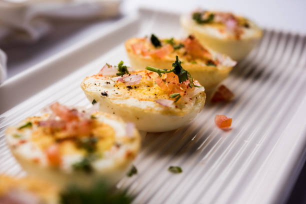 istock Fried hot boiled egg masala is a popular healthy breakfast or starter menu from India. With onion, coriander, black pepper, tomato and salt sprinkled over half of eggs 1089233450