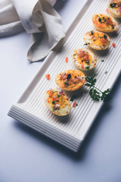 istock Fried hot boiled egg masala is a popular healthy breakfast or starter menu from India. With onion, coriander, black pepper, tomato and salt sprinkled over half of eggs 1089233958