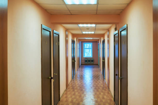 istock A long corridor with many doors and a window at the end. 1089249240
