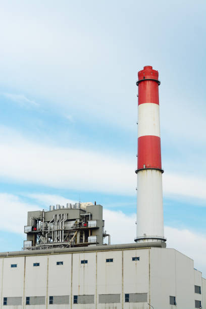 istock White and red vertical pipe flue-gas stack of power plant with blue sky background using as power plant industrial background concept. 1089258198