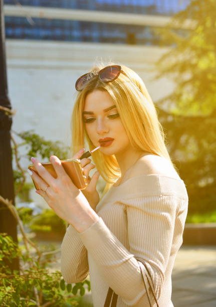 istock woman is applying makeup her lips. 1089262646