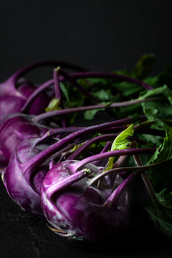 Purple kohlrabi. Shooting on a black background in a low key close-up.