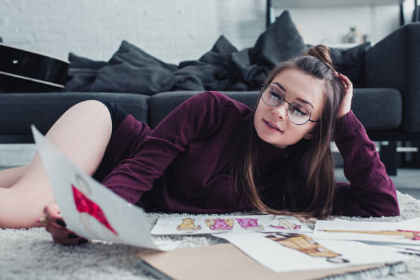 istock beautiful designer lying on carpet and holding sketch at home 1089281348