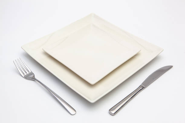 istock White square plate on the white wooden table. 1089282186
