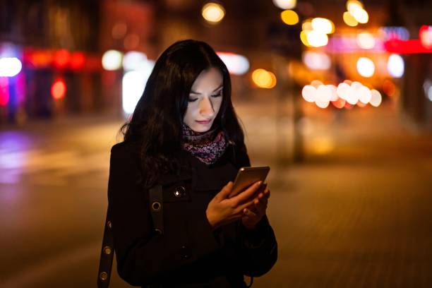 istock Young brunette woman using mobile phone at night. 1089282382