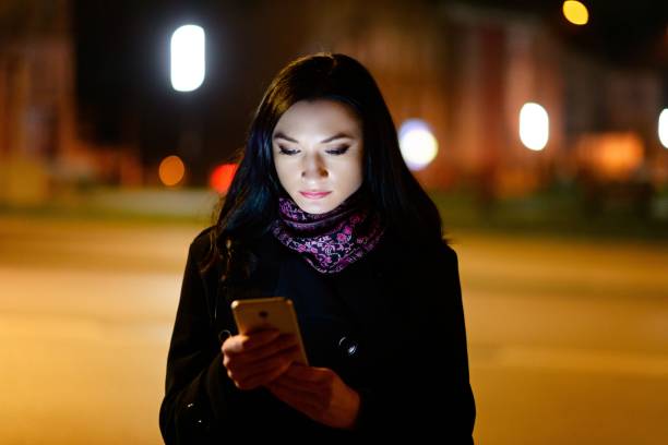 istock Young brunette woman using mobile phone at night. 1089282406