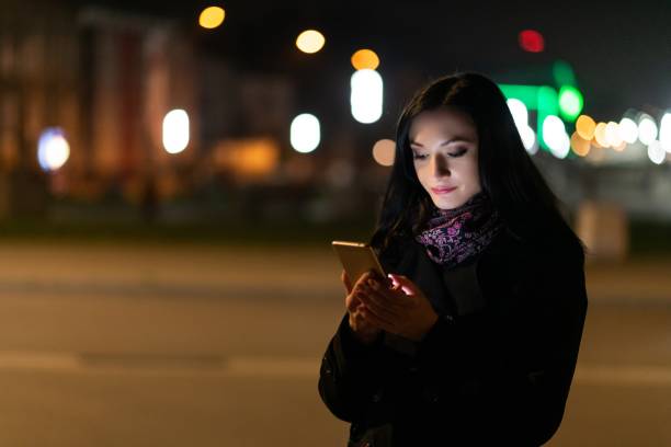 istock Young brunette woman using mobile phone at night. 1089282458