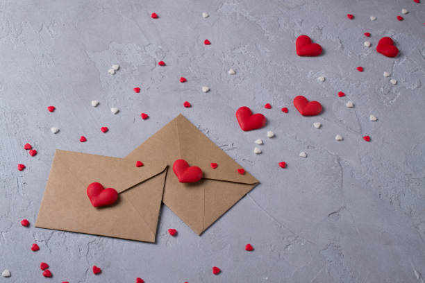 istock Two craft paper postal envelope with multicolor sweet sugar candy hearts. Love message or gift concept. 1089284236
