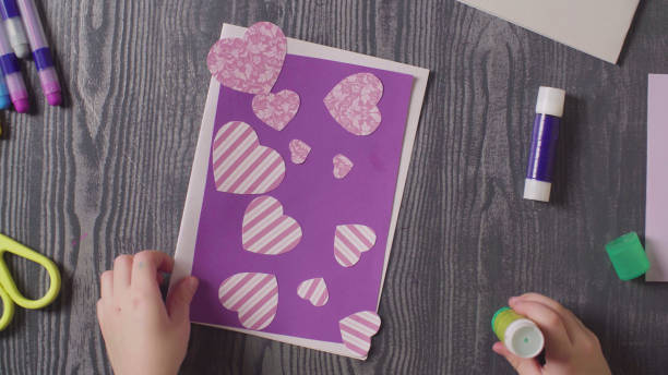 istock Girl's hands glueing a card. Valentine's Day 1089291264