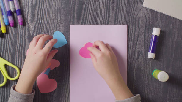 istock Girl's hands glueing a card. Valentine's Day 1089291312