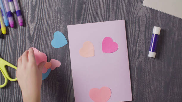 istock Girl's hands glueing a card. Valentine's Day 1089291400