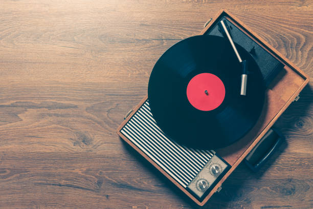 Vintage gramophone with a vynil record Retro Gramophone with a vinyl record on wooden table, top view and copy space,vintage style with split toning. record player stock pictures, royalty-free photos & images