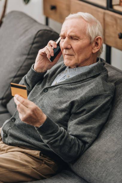 istock senior man talking on smartphone and looking at credit card 1089296794