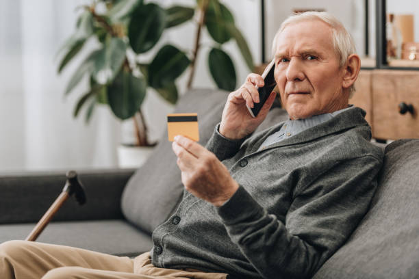 istock senior man talking on smartphone and holding credit card 1089296800
