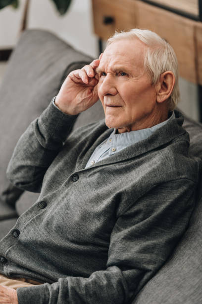 istock pensive pensioner with grey hair sitting on sofa 1089296812