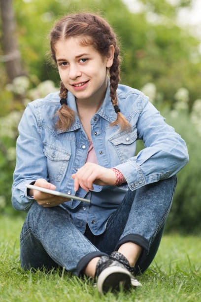 istock young girl using digital tablet while lying in green spring  garden 1089297572