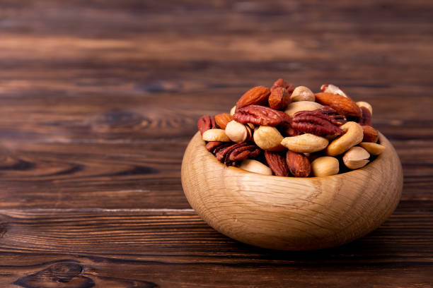 istock Different kinds of organic nuts in wooden bowl. 1089297988