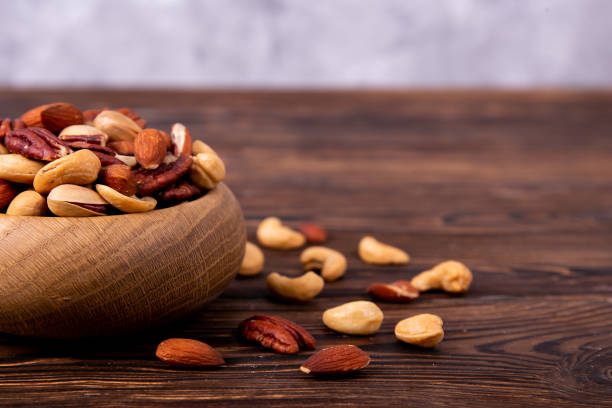 istock Different kinds of organic nuts in wooden bowl. 1089298004