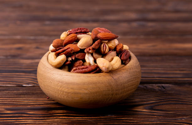 istock Different kinds of organic nuts in wooden bowl. 1089298006