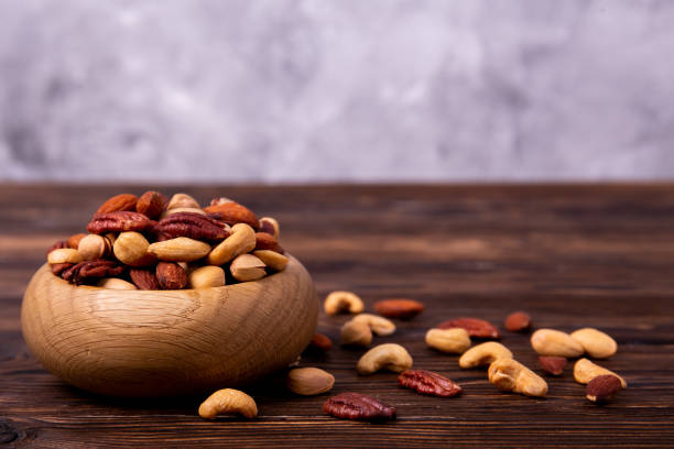 istock Different kinds of organic nuts in wooden bowl. 1089298020